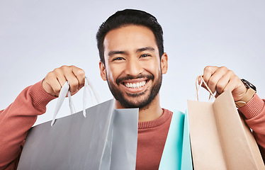 Image showing Shopping bag, studio portrait and man with happiness, retail product and smile for fashion spree, sales or Black Friday choice. Face, gift present and happy male customer excited on white background