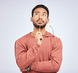 Image showing Decision, thinking and asian man in studio with glasses, questions and brainstorming on grey background. Why, idea and male person with emoji, body language or choice gesture, puzzled or solution