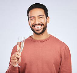 Image showing Champagne, portrait and asian man with glass in studio for success, celebration or victory on grey background. Wine, face and happy guy winner celebrating promotion, announcement or competition prize
