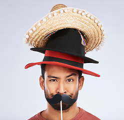 Image showing Photo booth, hat and portrait of man with mustache for comic, humor and funny joke in studio. Happy, Mexican party accessory and silly face of male person on gray background with sombrero for comedy