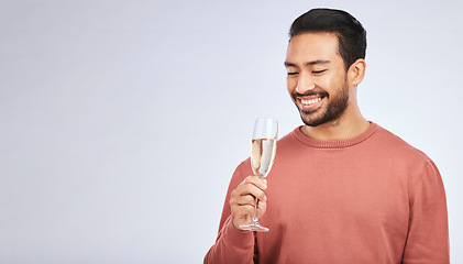 Image showing Champagne, celebration and asian man with glass in studio for success, milestone or victory on grey background. Wine, happy and male winner celebrating promotion, announcement or competition giveaway