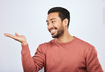 Image showing Hand holding, space and happy asian man in studio with mockup, promotion or news on grey background. Smile, face and male person with platform for menu, product placement or sale announcement