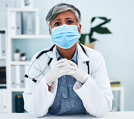 Image showing Healthcare, face mask and portrait of a female doctor in her office in the hospital for disease diagnosis. Gloves, concern and professional senior woman medical worker with virus prevention in clinic