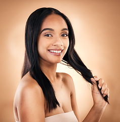 Image showing Portrait, hair and shampoo with a model woman in studio on a brown background for keratin treatment. Face, salon and smile with a happy young person looking confident about haircare cosmetics