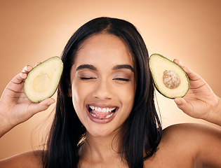 Image showing Face, tongue out and woman with avocado for skincare isolated on a brown background in studio. Fruit, funny and happy model with food for nutrition, health or vegan diet, omega 3 or natural cosmetics