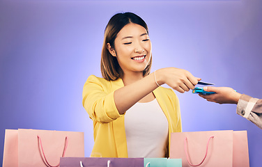 Image showing Card machine, shopping bag and woman POS, online payment and digital service or fashion fintech. Retail credit and cashier hands, asian customer or people at point of sale on studio purple background