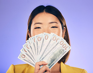 Image showing Money, beauty and woman cover face on purple studio background for winning, cash fan or financial prize. Lottery, bank and asian person or winner bonus, cosmetics secret or finance profit in portrait