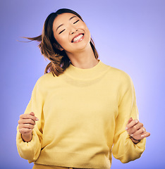 Image showing Happy asian woman, dancing and enjoying music, freedom or casual fashion against a purple studio background. Female person or model smile for energy, event or party in happiness for clothing style