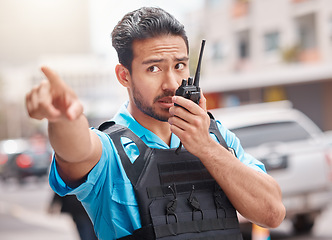 Image showing Man, police and pointing with walkie talkie in city for emergency dispatch, arrest or calling suspect. Male person, cop or law enforcement in radio signal for communication and safety in town street