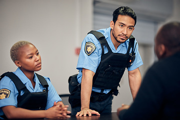Image showing Interrogation, arrest and police team with a suspect for questions as law enforcement officers. Security, crime or investigation with a serious man and woman cop talking to a witness for information