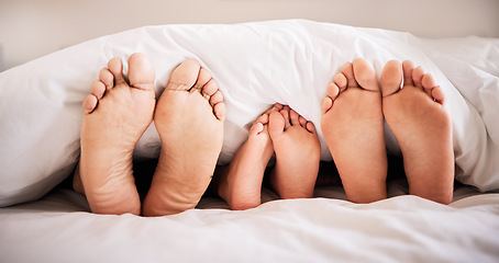 Image showing Sleeping, feet and family in bed together in the morning, lying in a row to relax in their home. Mom, dad and child dreaming in a bedroom while bonding over the weekend for love, safety or insurance