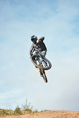 Image showing Mountain, bike jump and person cycling on bicycle for extreme sports competition stunt or training in nature. Skill, contest and athlete workout or practice sky trick for fitness with mockup space