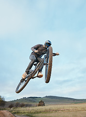 Image showing Cycling, fitness and man with bicycle jump for extreme sports, energy and adrenaline in nature. Action, bike and cyclist in countryside with speed, trick and skill, adventure or power on mockup space