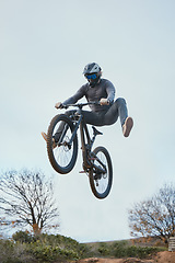 Image showing Mountain, bike jump and person cycling on bicycle for extreme sports competition stunt or training in nature. Skill, contest and professional athlete workout or action on sky or air trick for fitness