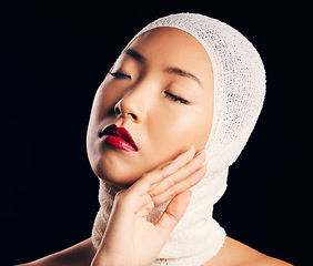 Image showing Asian woman, plastic surgery and bandage for skin, beauty and transformation with eyes closed by black background. Girl, model or patient with skincare, dermatology and pride for change in studio