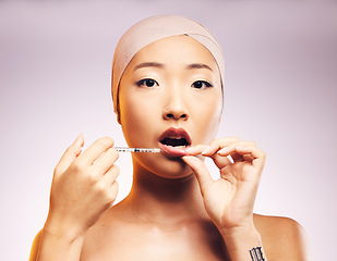 Image showing Beauty, lip filler and woman with injection for plastic surgery and portrait of luxury cosmetic dermatology in studio background. Lips, syringe and Asian model with facial treatment for aesthetic