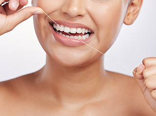 Image showing Mouth, face and woman floss teeth for dental health, care or gingivitis on studio background. Closeup of female model, oral thread and cleaning string for fresh breath, tooth hygiene or healthy habit