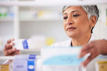 Image showing Pharmacist, shelf and a woman with a medicine box in a pharmacy for inventory or prescription. Mature female employee in healthcare, pharmaceutical and medical industry reading product information