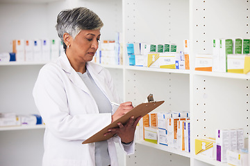 Image showing Pharmacist, medicine and a woman writing on a clipboard in a pharmacy for inventory or checklist. Mature female employee check shelf for management in healthcare, pharmaceutical and medical industry