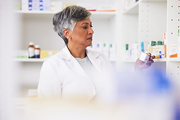 Image showing Pharmacist, shelf and a woman reading a medicine box label in a pharmacy for knowledge. Mature female employee in healthcare, pharmaceutical and medical industry to check product information on stock