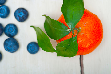 Image showing tangerine and blueberry on white table