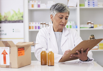 Image showing Woman, doctor and clipboard at pharmacy for inventory inspection, logistics or delivery at drug store. Senior female person, medical or healthcare professional checking pharmaceutical stock or list