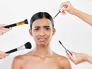 Image showing Makeup, brush and anxiety, woman with beauty shine and overwhelmed with beautician on white background. Doubt with cosmetics, tools and hands crowd female model in studio, cosmetology and skin glow