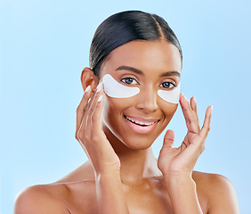 Image showing Happy, skincare and portrait of woman with patches for eyes, dark circles and treatment. Smile, face and Indian girl or model with a facial collagen for a glow isolated on a blue background in studio