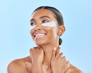 Image showing Eye patch, face and beauty of a happy woman with natural skin glow on a blue background. Dermatology, collagen mask and cosmetics of Indian person for facial shine, wellness or self care in studio