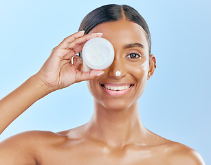 Image showing Cream, container and beauty, woman with skincare and cosmetics product isolated on blue background. Lotion on face, sunscreen and facial mask, smile and moisturizer with female model and dermatology