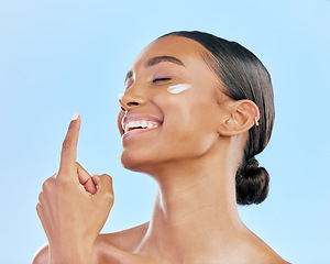 Image showing Face cream, skin and beauty of a happy woman with natural glow on a blue background. Dermatology, moisturizer and cosmetics of an Indian female model for facial shine, wellness or self care in studio