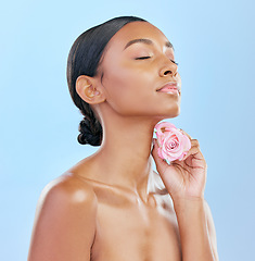 Image showing Woman, rose and beauty with natural cosmetics and eco friendly skincare on blue background. Flower, nature and sustainable dermatology with skin glow, female model and floral with shine in studio