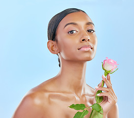 Image showing Woman, skincare and rose with natural beauty, portrait and eco friendly dermatology on blue background. Female model, face and shine, healthy skin glow and flower, nature and cosmetics in studio