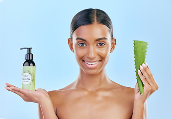 Image showing Woman, aloe vera and skincare in studio portrait with smile, natural choice and happy by blue background. Girl, model and cactus plant for health, wellness and bottle with serum, care and facial glow