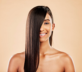 Image showing Hair care, smile and portrait of a woman on a studio background with salon treatment. Beauty, happy and headshot of an Indian model or girl showing healthy shampoo results isolated on a backdrop