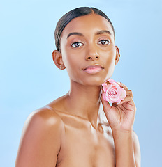 Image showing Woman, rose and natural beauty with cosmetics and eco friendly skincare on blue background. Flower, nature and sustainable dermatology with skin glow, female model and portrait in studio