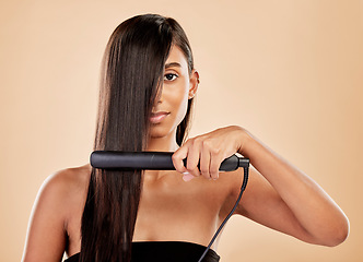Image showing Beauty, flat iron and hair care of a woman in studio with natural glow and shine. Straightener, cosmetics and wellness of Indian person for hairdresser, hot tools or salon results on beige background