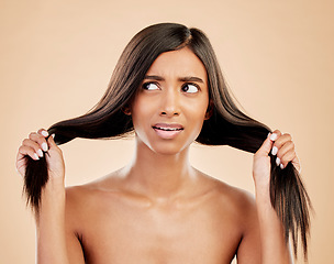 Image showing Thinking, hair care and a woman with a problem on a studio background with anxiety and confused. Ideas, cosmetics and an Indian girl or model with hairstyle stress or fail isolated on a backdrop