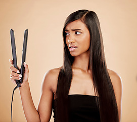 Image showing Hair straightener, woman is scared and beauty, hairstyle and appliance fail on studio background. Keratin treatment, problem with electric flat iron and female model, haircare crisis and treatment