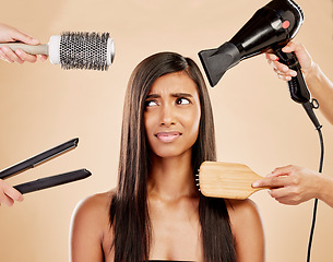 Image showing Hair, tools and worry of woman with product for beauty, heat treatment and unhappy on studio background. Indian female model, stress and anxiety for brush, hairdryer and flat iron styling equipment