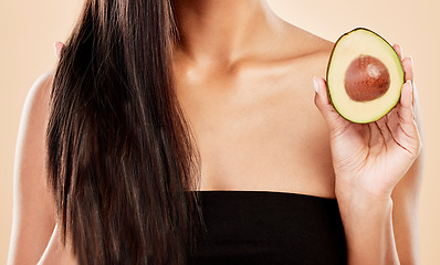 Image showing Closeup, woman and avocado for hair, beauty or cosmetic treatment for natural growth, shampoo cosmetics or studio background. Female model, green fruits or vegan dermatology of healthy hairstyle care