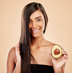 Image showing Portrait, woman and avocado for hair, beauty or cosmetic treatment of natural growth on studio background. Happy indian female model, green fruits and vegan dermatology for keratin and aesthetic glow