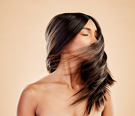 Image showing Woman, beauty and shake hair in studio for aesthetic shine, volume and smooth shampoo results. Indian female model, salon treatment and wind in hairstyle for growth, soft texture and cosmetic care