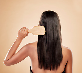 Image showing Back of woman, brush and hair care in studio, background and grooming of smooth texture. Beauty, growth shampoo and female model with comb tools for aesthetic hairstyle, keratin treatment and shine