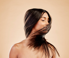 Image showing Woman, shake hair and beauty with growth, texture and shine with natural cosmetics on studio background. Indian female model, satisfied with salon treatment and Brazilian, hairstyle and haircare