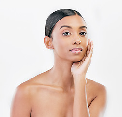 Image showing Beauty, hand on face and portrait a woman with natural skincare isolated on a white background. Dermatology, makeup glow and cosmetics with Indian female model for facial shine or self care in studio