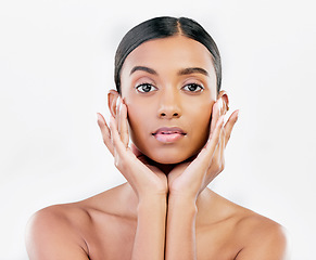 Image showing Beauty, portrait and a woman with hands on face for natural skincare isolated on a white background. Dermatology, makeup glow and cosmetics with a serious Indian person for facial shine and self care