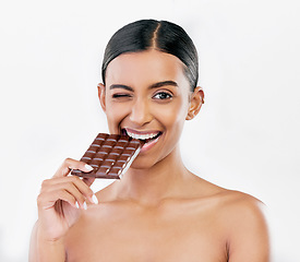 Image showing Happy woman, chocolate and candy bite for diet or unhealthy eating against a white studio background. Portrait of female person or model with cocoa slab, block or bar for snack or diabetes on mockup