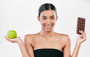 Image showing Apple, chocolate and portrait of woman for healthy food choice, sugar and beauty isolated on studio white background. Dessert, green fruit and face of indian person detox, vegan or skincare decision