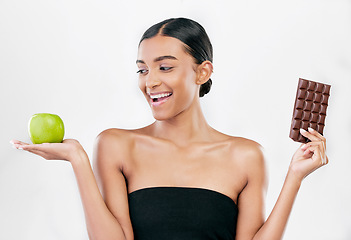 Image showing Apple, chocolate and happy woman for healthy food choice, sugar and skincare isolated on studio, white background. Dessert, green fruit and african person detox, vegan beauty or dermatology decision